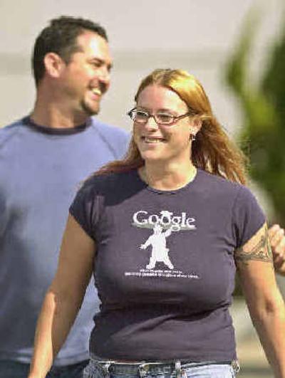 
Google Inc. workers who refused to be identified smile and laugh outside of company headquarters in Mountain View, Calif., Thursday morning after shares of Google surged nearly 22 percent in their market debut.
 (Associated Press / The Spokesman-Review)