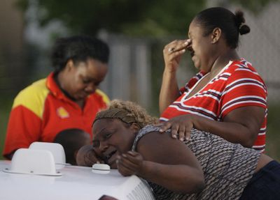 Friends of Kerda Harris, not shown, the mother of two of five children swept away by high water in Houston, react during the search Saturday.  (Associated Press / The Spokesman-Review)