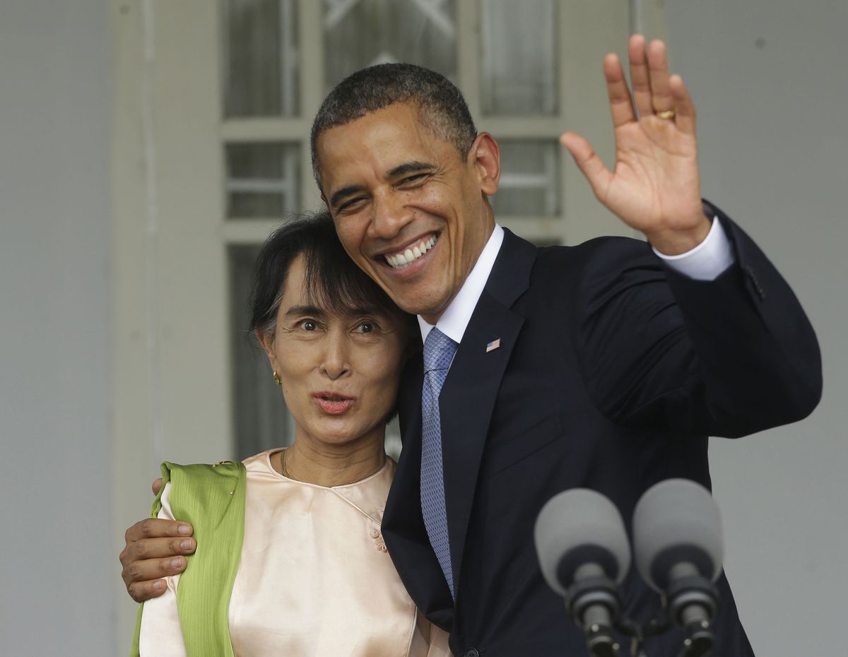 U.S. President Barack Obama, right, waves as he embraces Myanmar democracy activist Aung San Suu Kyi after addressing members of the media at Suu Kyi