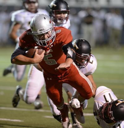 Ferris' quarterback Mitch Pike, on the keeper play, dives forward for the touchdown while towing University defenders, Thursday, Sept. 18, 2014 at Joe Albi Stadium. (Jesse Tinsley / The Spokesman-Review)