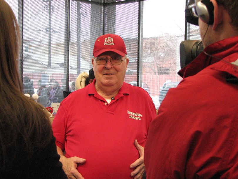 Hillyard Santa Clyde Decker is framed by TV reporters on the opening morning of his annual toy give-away on Dec. 13, 2010. Decker will be giving away donated toys to more than 3,000 kids. Bank of America's Hillyard branch is hosting the toy give-away and have lent Decker a vault for the toys in the basement. (Pia Hallenberg)