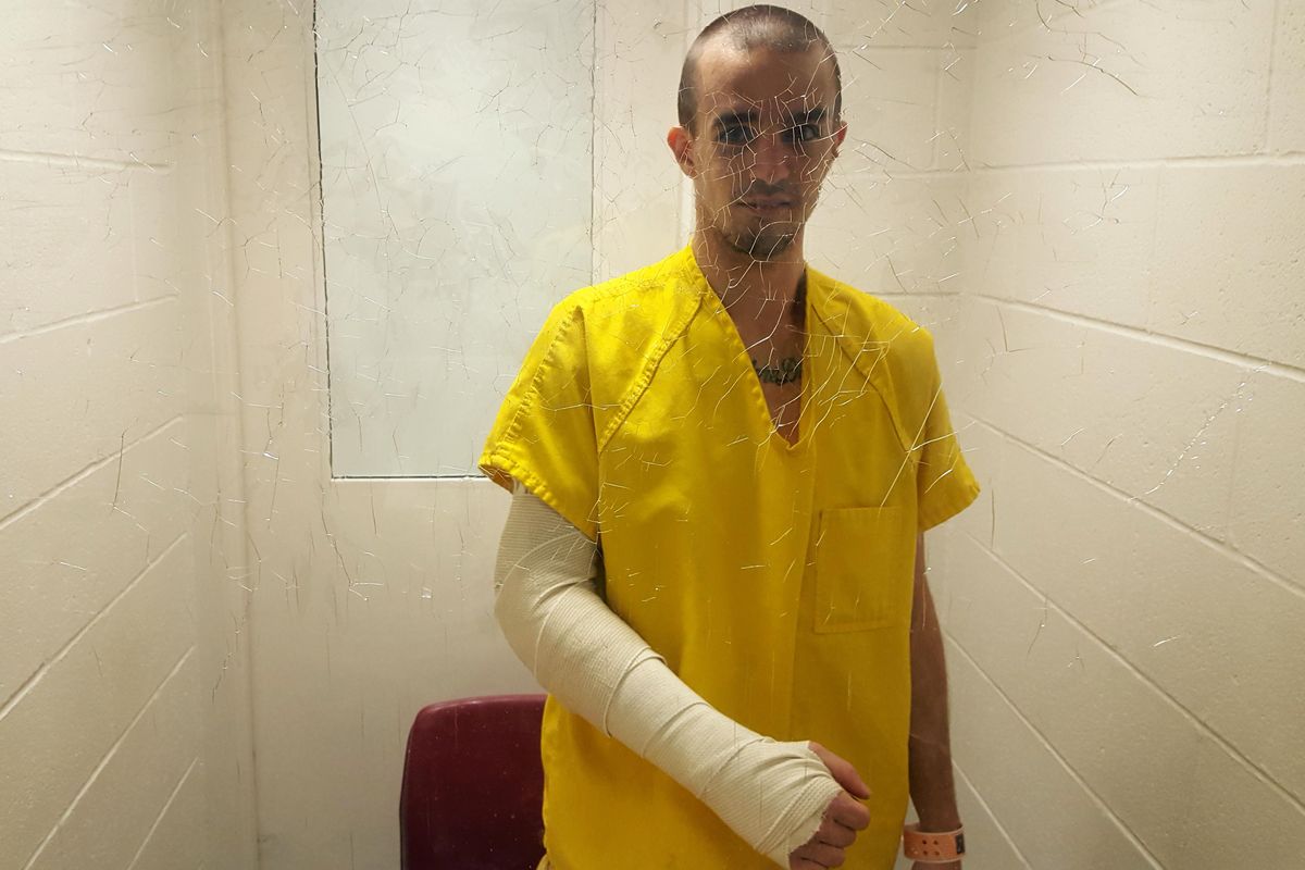 Bryan Monnin poses behind the glass of a visiting booth in the Spokane County Jail on Nov. 21, 2016. He was awaiting treatment for a broken elbow. (Chad Sokol / The Spokesman-Review)