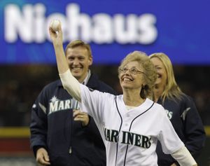 As family members look on, Marylin Niehaus, the widow of Mariners announcer Dave Niehaus, who died last year, throws out the first pitch of the Mariners home opener baseball game against the Cleveland Indians, Friday, April 8, 2011, in Seattle. (Elaine Thompson / Associated Press)