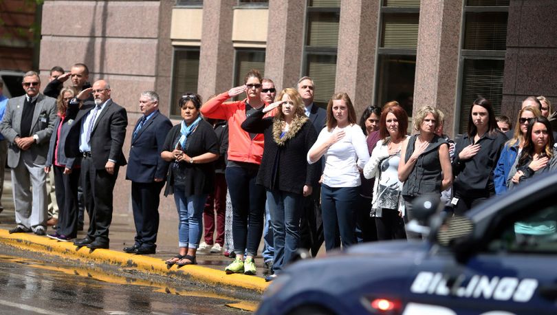 A crowd of mainly Yellowstone County Courthouse employees lines up along North 27th Street as a motorcade passes carrying the body of Broadwater County Sheriff's Deputy Mason Moore to the State Medical Examiner's office, Tuesday, May 16, 2017 in Billings, Mont. Moore, a sheriff's deputy was killed early Tuesday in a shootout that prompted a middle-of-the-night pursuit that spanned more than 100 miles (161 kilometers) across southwestern Montana, involving several law enforcement agencies.(Casey Page/The Billings Gazette via AP)
