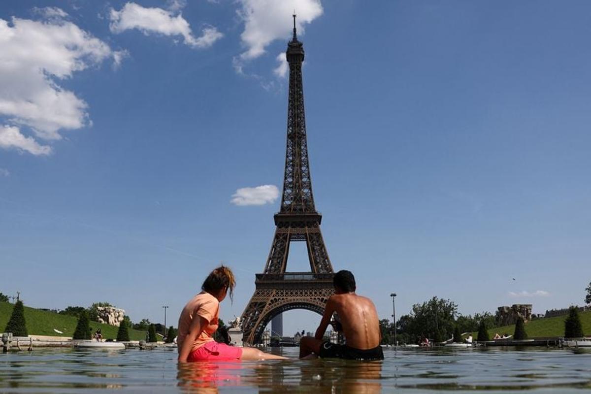 People cool off Thursday in the Trocadero Fountain next to the Eiffel Tower in Paris as temperatures rise during a heat wave affecting a large part of France.  (Abdul Saboor/Reuters)