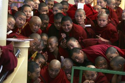 Exiled Tibetan Buddhist monks watch from a balcony in Dharmsala, India, during a ceremony Tuesday to mark the 50th anniversary of the failed Tibetan uprising against Chinese rule.    (Associated Press / The Spokesman-Review)