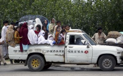 Unregistered displaced Pakistanis wait along a roadside after police stopped them from proceeding to their hometowns in Shergarh near Mardan, Pakistan, on Monday.  (Associated Press / The Spokesman-Review)