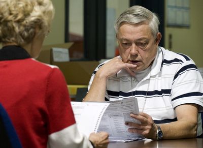 Spokane County elections workers Christa McQueen and Herman Bernards compare remade and original ballots in the 6th Legislative District race Tuesday.  (Colin Mulvany / The Spokesman-Review)