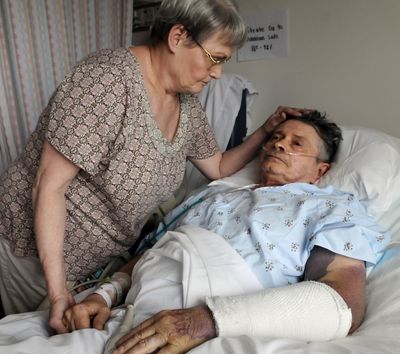 Helen Widener, 69, comforts her husband, Dennis, 66, in Providence Sacred Heart Medical Center on June 29. Dennis, who was injured in a hit-and-run accident while he was riding his bicycle near the corner of Division Street and Garland Avenue, died Wednesday. (Dan Pelle)