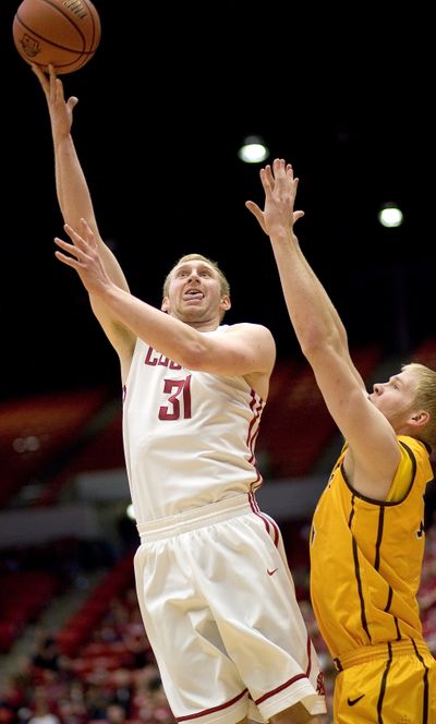 WSU’s Abe Lodwick shoots over Wyoming center Adam Waddell. (Associated Press)