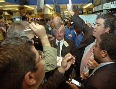
Specialists conduct trading Friday on the floor of the New York Stock Exchange. The Dow Jones industrial average fell 147.70 points.
 (Associated Press / The Spokesman-Review)