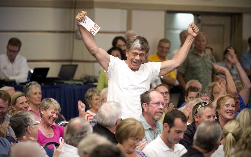 Tom Wielgos celebrates after entering the winning bid for the Priest Lake site where he has a home on Thursday. His was the only bid on the property during the auction at the Coeur d’Alene Resort. The state of Idaho auctioned long-leased sites, many with cabins or houses on them. In most cases cabin owners bought the land under their rural vacation homes. (Jesse Tinsley)