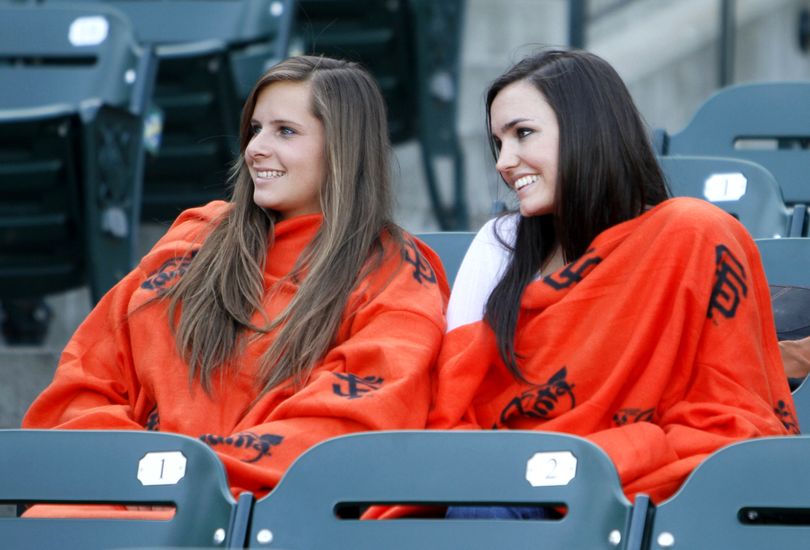 Jenna Landry, left, of Pleasant Hill, Calif., and Ricki Radanovich, right, of Danville, Calif., wear their new Snuggies while watching the San Francisco Giants take batting practice before their baseball game against the St. Louis Cardinals in San Francisco, Friday, April 23, 2010.  Giants Snuggies were given away to the first 20,000 fans at the game. (Eric Risberg / Associated Press)