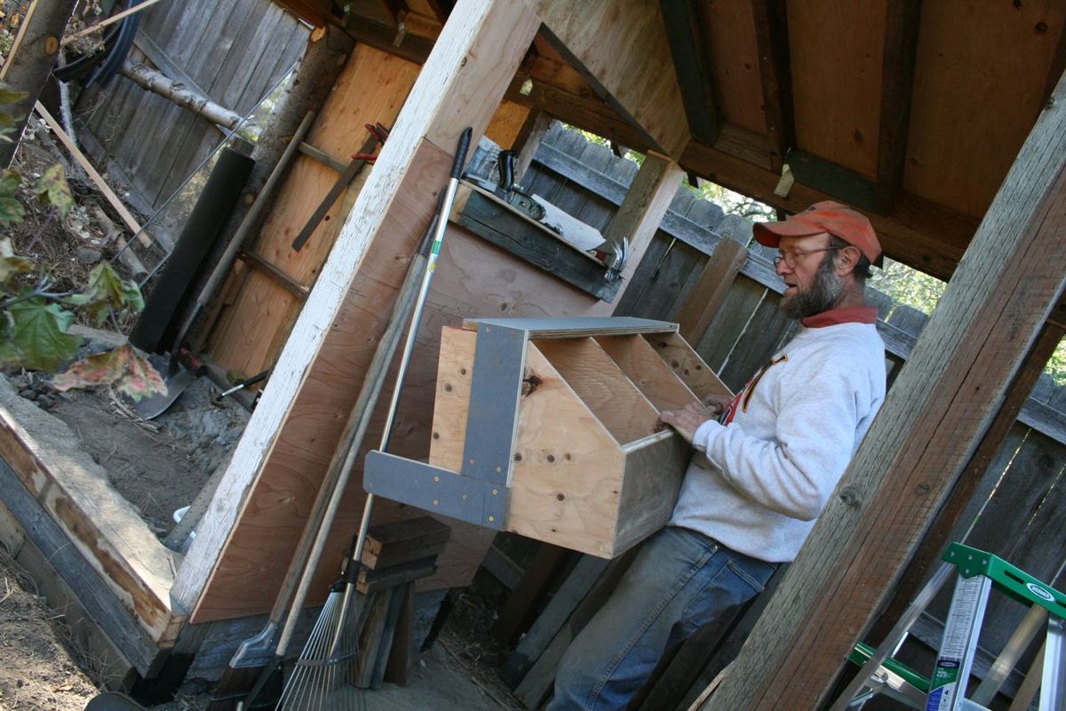 Dan Treecroft holds up a nest box he made for a chicken coop he