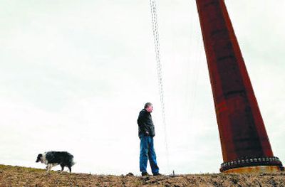 Martin Marler walks with his dog Chrissy next to one of several transmission line poles on his Colfax farm. Marler wants compensation for the added voltage that runs through the lines he suspects are serving California customers. 
 (Photos by BRIAN PLONKA / The Spokesman-Review)