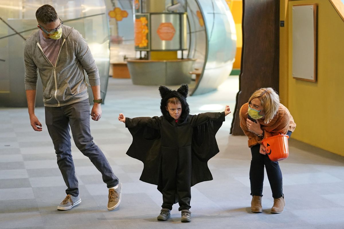 Grayson Martin, 3, poses in his costume as his parents, Rachelle and Patrick Martin, look on during a visit Thursday to Discovery Gateway Children’s Museum in Salt Lake City.  (Rick Bowmer)