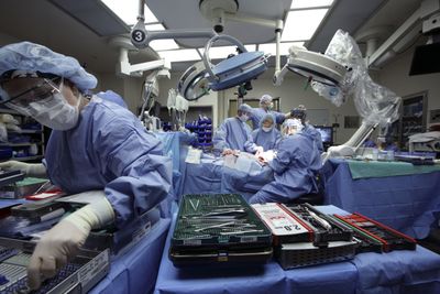 In this photo released by the Cleveland Clinic, doctors perform a near-total face transplant. The prestigious clinic has begun a hiring and salary freeze across the 33,000-worker health system; it also restricted travel and use of consultants and contractors. (Associated Press / The Spokesman-Review)