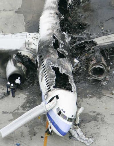 
Investigators examine a wrecked China Airlines Boeing 737-800 on Monday after it exploded in flames at Naha Airport in southern Japan. All 165 people aboard escaped alive, officials said.Associated Press
 (Associated Press / The Spokesman-Review)