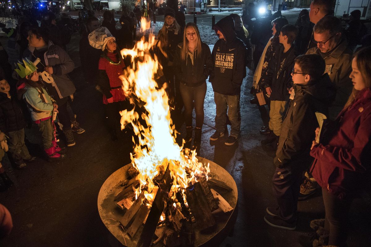 At First Night Spokane 2016, people gather around a warming bonfire in Riverfront Park. (Colin Mulvany / The Spokesman-Review)