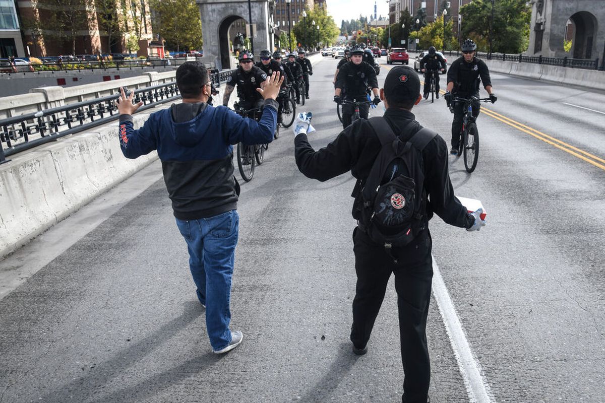 Protesters shout “Hand up, don’t shoot” at Spokane police officers during the Occupy Spokane nonviolent protest for Breonna Taylor Sept. 26 in Spokane.  (DAN PELLE/THE SPOKESMAN-REVIEW)