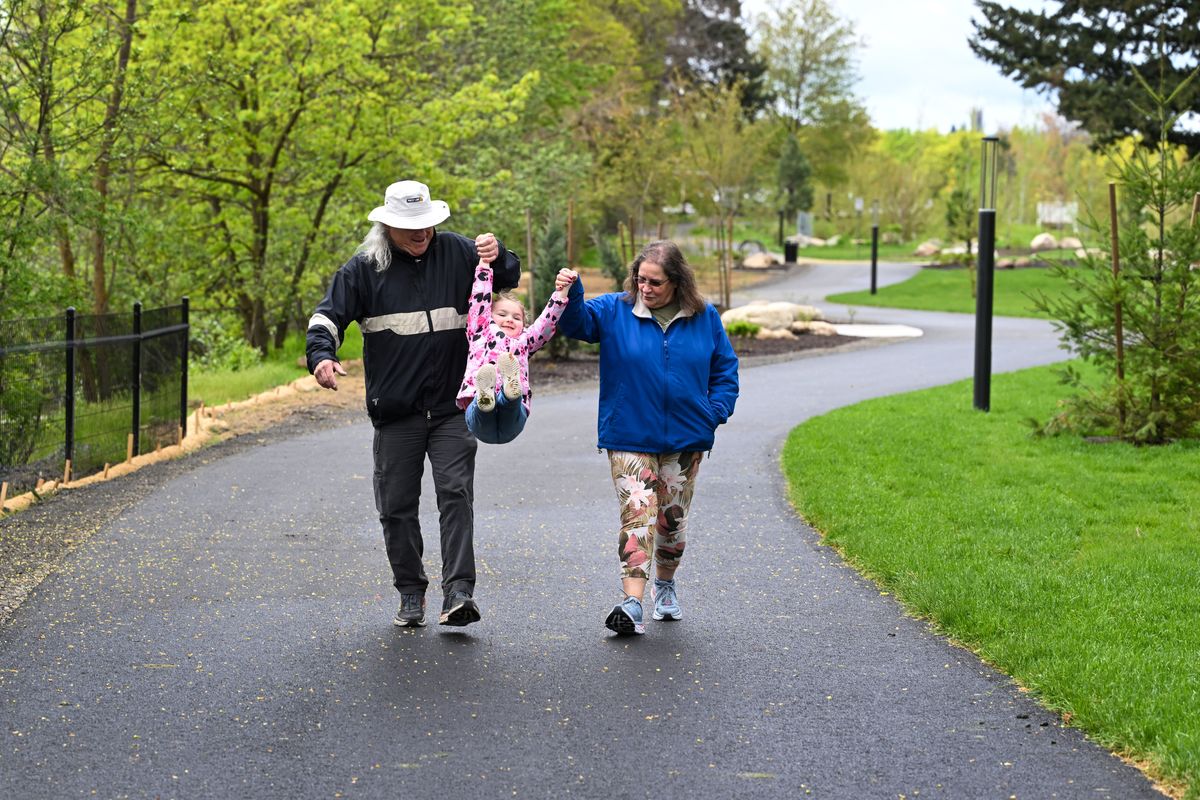 Peter and Norma Harras take their granddaughter Myra Harras, 3, for a stroll in the newly opened Upriver Park. A grand opening is planned in June, but the fencing has come down and residents are encouraged to use the park right now.  (COLIN MULVANY/THE SPOKESMAN-REVIEW)