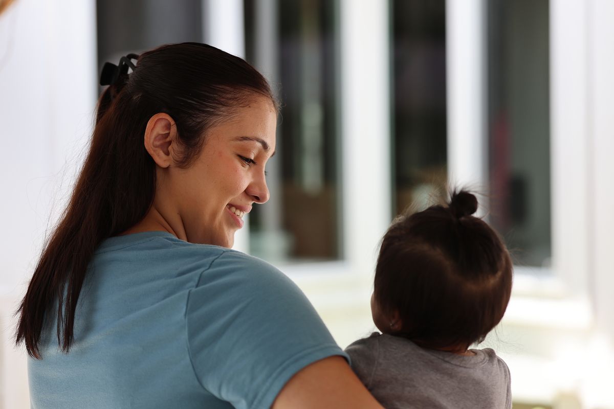 Jennifer Cortez, left, child care assistant, plays with a child at a home day care run by Zoila Carolina Toma, not pictured, in Lakewood, Calif., on Friday, June 20, 2025. (Los Angeles Times)