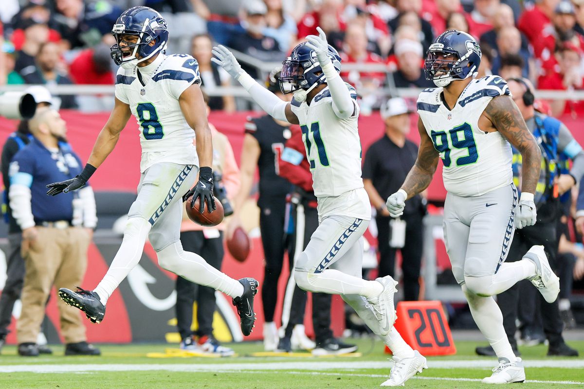 Seattle Seahawks cornerback Coby Bryant, left, celebrates his interception with cornerback Devon Witherspoon, center, and defensive end Leonard Williams against the Arizona Cardinals on Dec. 8. All three players return as starters on the Seahawks defense. (Tribune News Service)