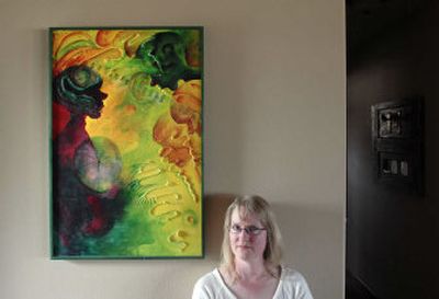 
Denise Bowles and one of her pieces, Osculating Pulse, in the entryway of her Greenacres home. Below are heads Bowles often uses in her art.
 (The Spokesman-Review)