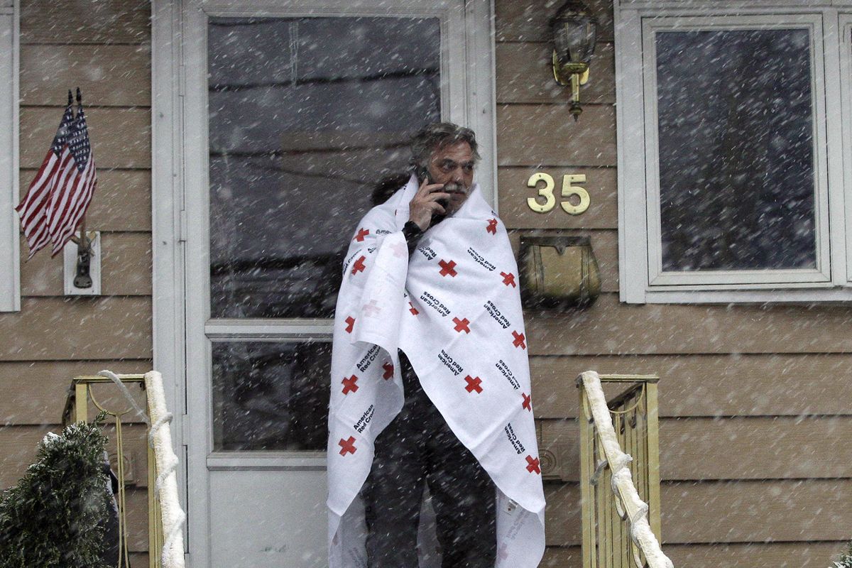 Ben Colontonio talks on his cell phone wrapped in a blanket donated by the American Red Cross as a Nor