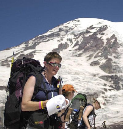 
Sherry Miller, left, takes a break as she hikes toward the Camp Muir base camp at Mount Rainier on Wednesday. Miller, a breast cancer survivor, was one of nearly 40 women climbing the mountain to raise awareness about breast cancer. 
 (Associated Press / The Spokesman-Review)
