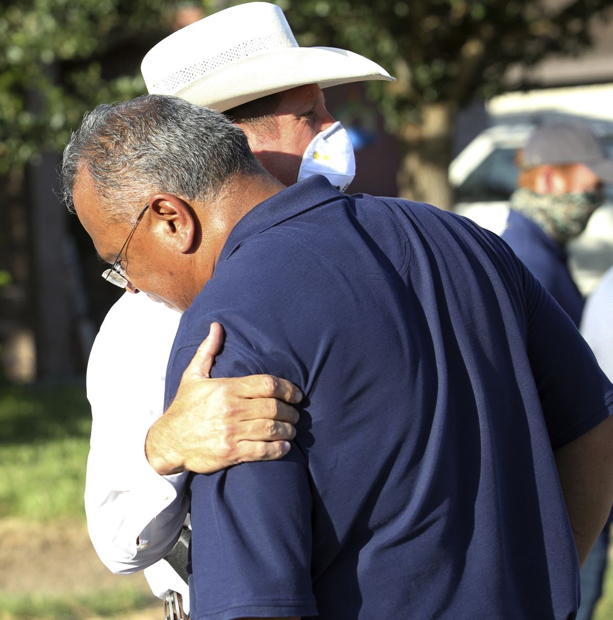 McAllen Police Chief Victor Rodriguez, foreground, is hugged by a Texas Ranger after speaking at a news conference near the scene of a shooting where two of his officers were shot and killed reportedly responding to a disturbance call, Saturday, July 11, 2020, in McAllen, Texas.  (Delcia Lopez)