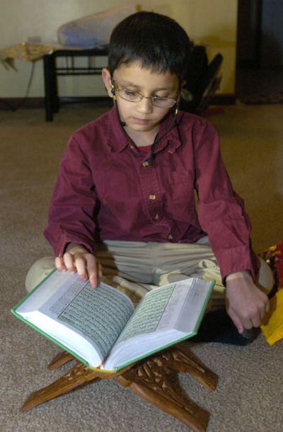 
Taha Ahmed reads the Quran at his home in Niskayuna, N.Y. last month. Learning the Quran is part of an important rite of passage for Muslims called Ameen.
 (ASSOCIATED PRESS PHOTOS / The Spokesman-Review)