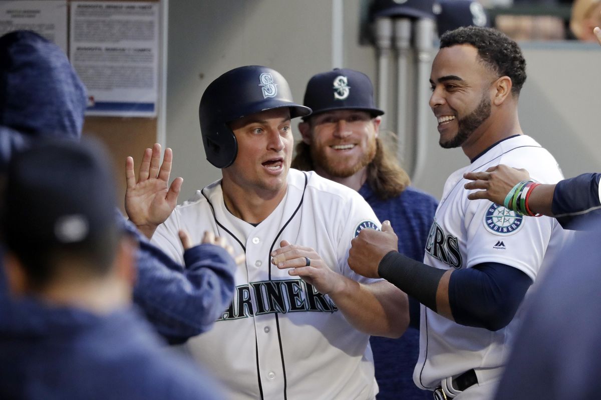 Seattle’s Kyle Seager, left, is congratulated after scoring on a passed ball during the fourth inning against the Texas Rangers Wednesday in Seattle. (Elaine Thompson / AP)