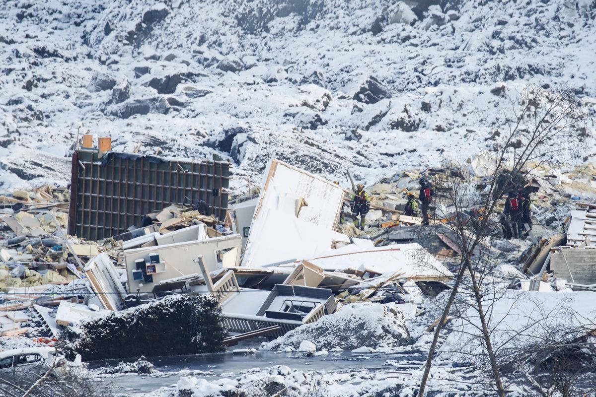 Workers search the area Tuesday from a large landslide that destroyed several houses at Ask in Norway. Several homes were taken by the landslide early Dec. 30, killing seven people; three are still reported missing. (Terje Pedersen)