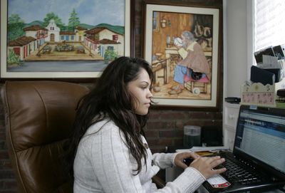 Tatiana Gallego, 25, who was laid off in December, uses her laptop at her home in Elmwood Park, N.J.  (Associated Press / The Spokesman-Review)