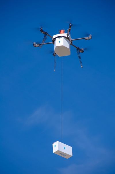 In this  photo provided by Flirtey, an independent drone delivery company,  a fully autonomous drone delivers a box with bottled water, emergency food and a first aid kit to an area in Hawthorne, Nev. (Associated Press)