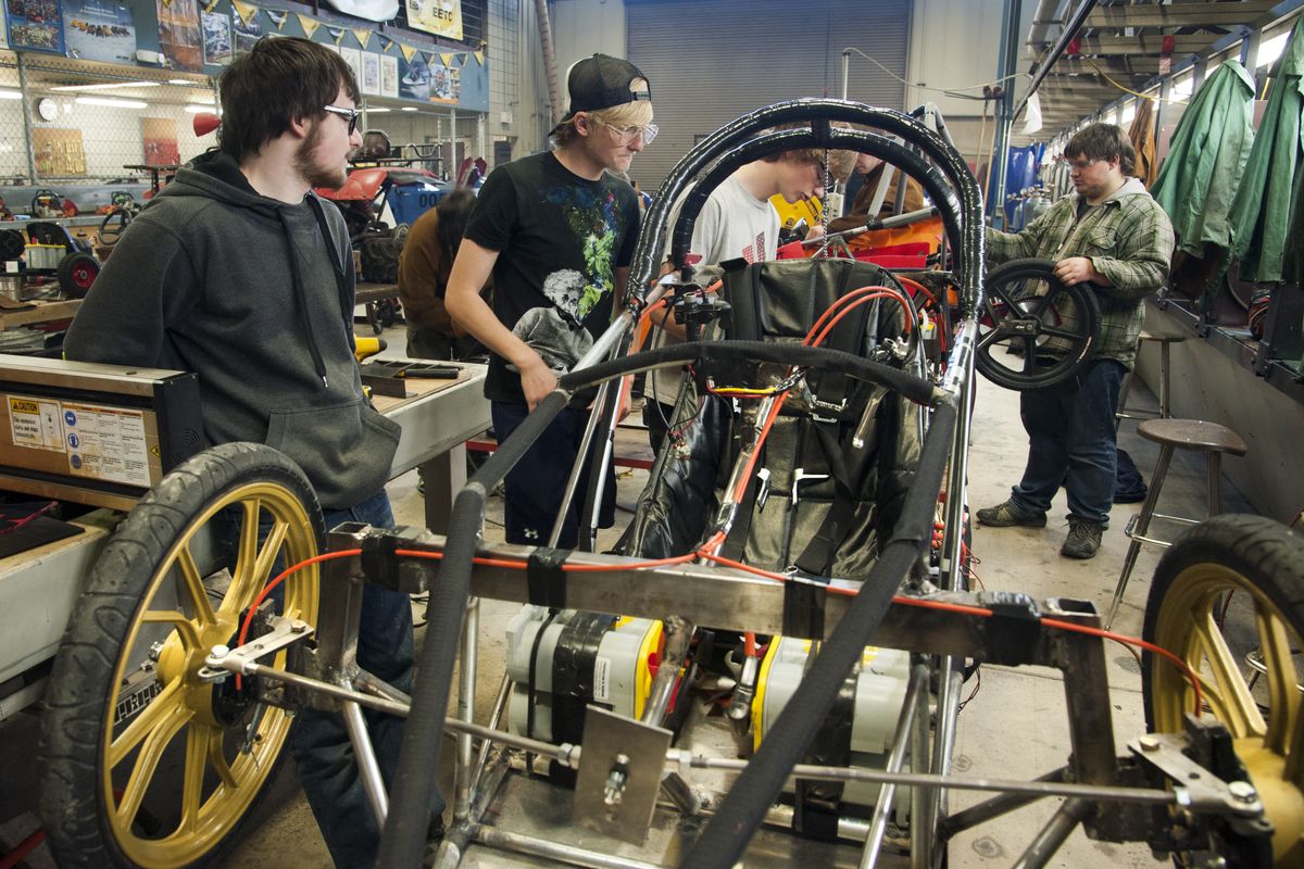 Riverside High School students Eric Dearment, Brandon Hartill and Cameron Supanchick, of the Voltage Racing Team, work on their electric car, as A.J. Wood, far right, works on another vehicle, April 29, at the school. (Dan Pelle)