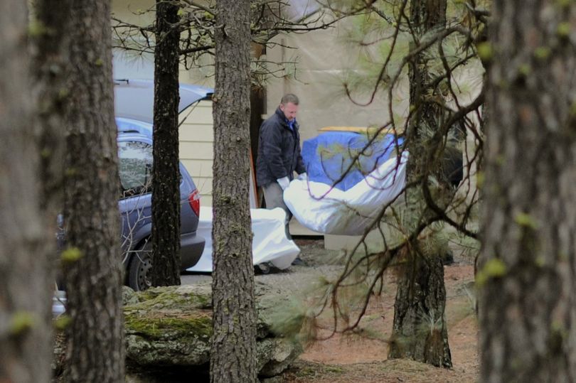 The body of Dustin Gilman is placed in the medical examiner's van after it was discovered on property along the Little Spokane River on Monday. (Colin Mulvany)