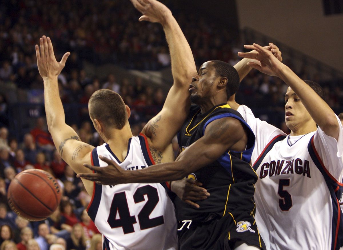 MSUB’s Mario Burns meets GU’s Josh Heytvelt and Austin Day.  (Associated Press / The Spokesman-Review)