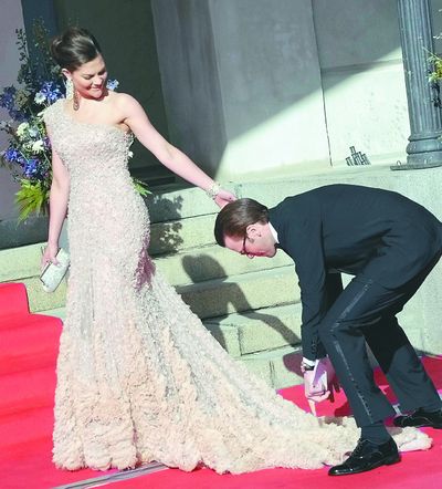 Sweden’s Crown Princess Victoria gets help with her dress from Daniel Westling, whom she married Saturday, on arrival at the Swedish government’s dinner in Stockholm on Friday.  (Associated Press)