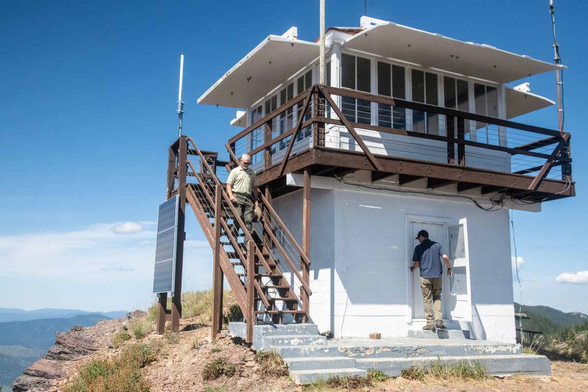 Rich Matrisciano, left, and Jed Friedman look on Aug. 11 at the progress of restoration of the Little Guard lookout tower east of Coeur d’Alene.  (Michael Wright/The Spokesman-Review)