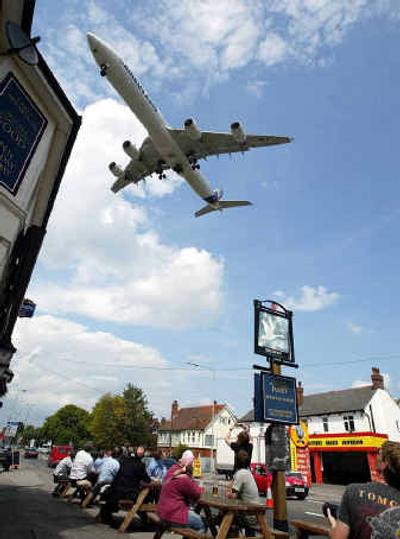 
A group of people watch as an Airbus A340 passes overhead to make a landing recently in England. 
 (Associated Press / The Spokesman-Review)
