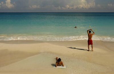 
People enjoy the beach in Cancun, Mexico. After Hurricane Wilma hit last year, the beach and buildings were damaged. The new beach was built by pumping 96 million cubic feet  of sand from the ocean floor.
 (Associated Press photos / The Spokesman-Review)