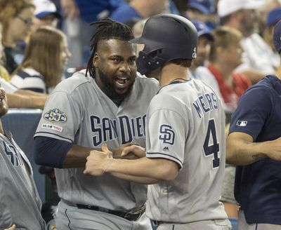 San Diego’s Wil Myers is greeted by teammate Franmil Reyes after he hit a two-run home run against the Blue Jays in the eighth inning in Toronto on Saturday. (Fred Thornhill / Associated Press)