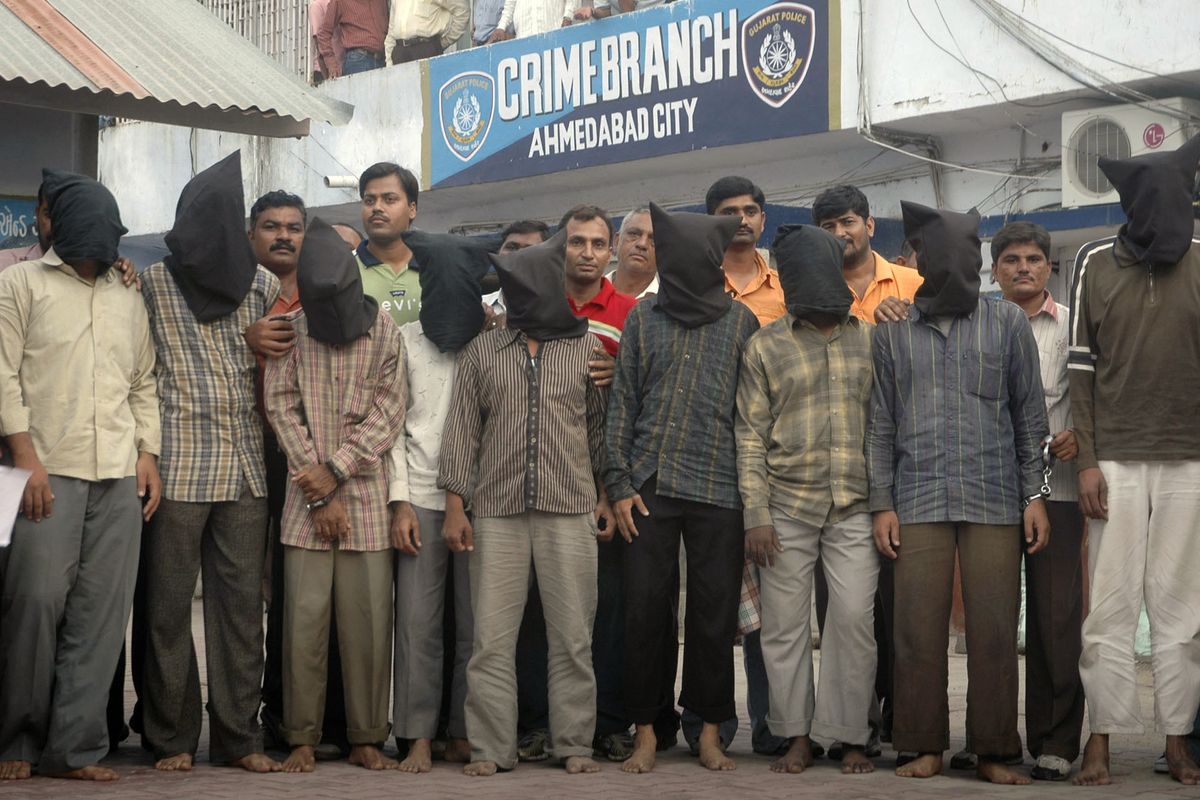 FILE- Nine men, wearing black hoods to conceal their identity, arrested by the Ahmedabad crime branch for allegedly conducting a series of bombings, are shown to the media in Ahmadabad, India, Saturday, Aug. 16, 2008. A court on Friday sentenced 38 convicts to death by hanging after finding them guilty of 2008 serial blasts that rocked a western Indian city that killed more than 50 people and left 200 injured. This is the first time that so many accused have been sentenced to death in a single case in India. The punishment will now be required to be confirmed by a higher court.  (Ajit Solanki)