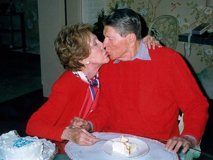 Former President Ronald Reagan, who was a faithful writer of love letters, is kissed by wife Nancy on his 89th birthday in 2000. (Associated Press)