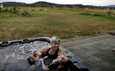 “He just loves warm water,” Laurie Knapp says as she introduces her son, Ryan, 15, to a new hot tub at their Post Falls home on Tuesday. The Wishing Star Foundation donated the hot tub for Ryan, who has cerebral palsy.  (Kathy Plonka / The Spokesman-Review)