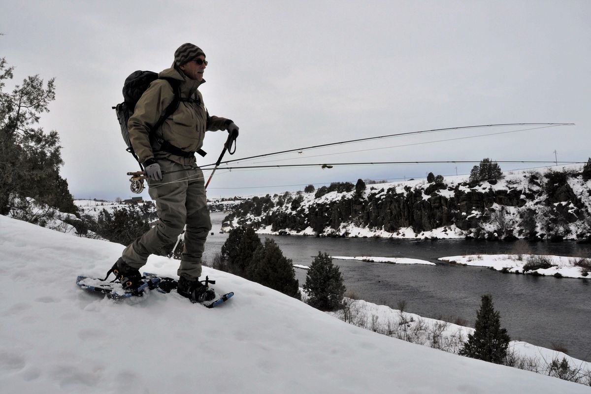 Snowshoes fixed to wading boots help fly fisher David Moershel float over deep, crusty snow as he accesses a stretch of Idaho’s Henry’s Fork in February. (Rich Landers / The Spokesman-Review)