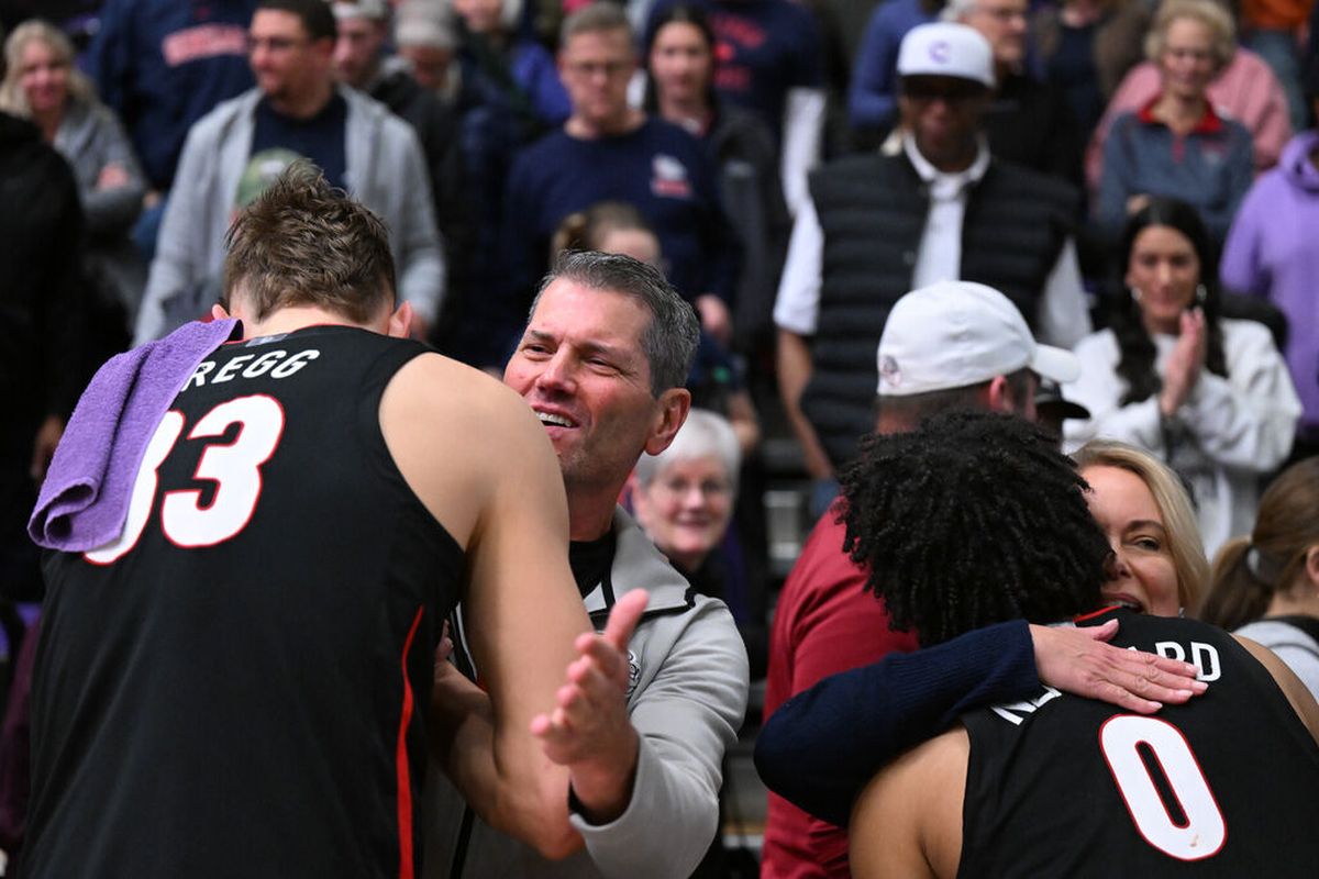 Gonzaga guard Ryan Nembhard, right, and forward Ben Gregg embrace fans after the Bulldogs defeated the Portland Pilots 86-65 Thursday in West Coast Conference play at the Chiles Center in Portland.  (Tyler Tjomsland / The Spokesman-Review)