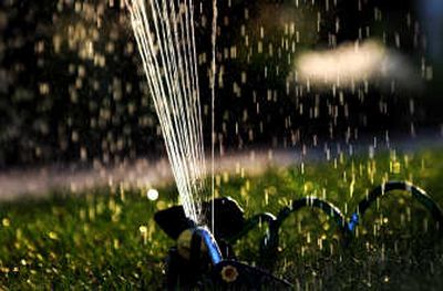 A sprinkler spits out water in a Spokane yard on a recent evening. 
 (Photos by RAJAH BOSE / The Spokesman-Review)
